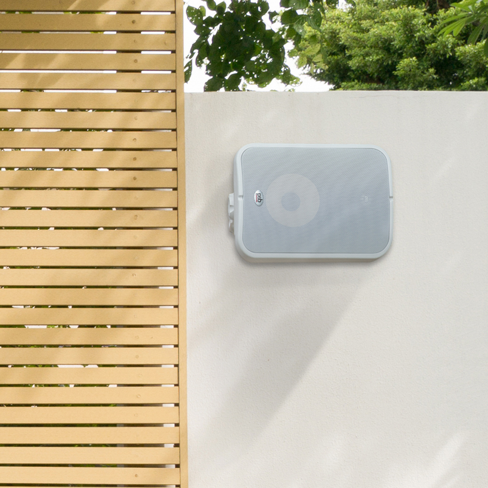 A white CS500 outdoor speaker mounted on an exterior property wall