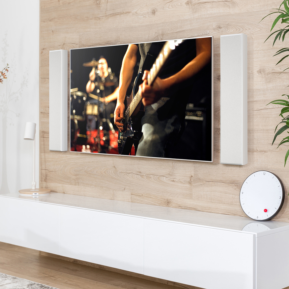 A pair of white PWM2 speakers flanking a TV on a wall