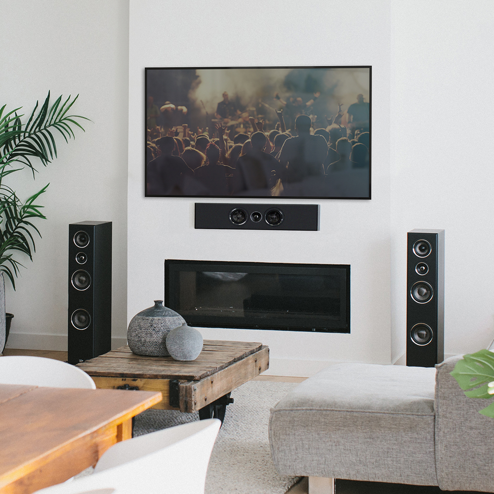 A black PWM1 on-wall speaker mounted horizontally below a TV