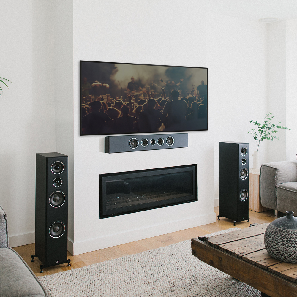 A black PWM2 mounted horizontally to a wall below a large TV