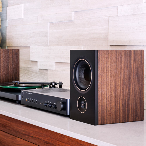 PSB Alpha P5 walnut speakers with NAD amplifier and a NAD turntable on a media table.