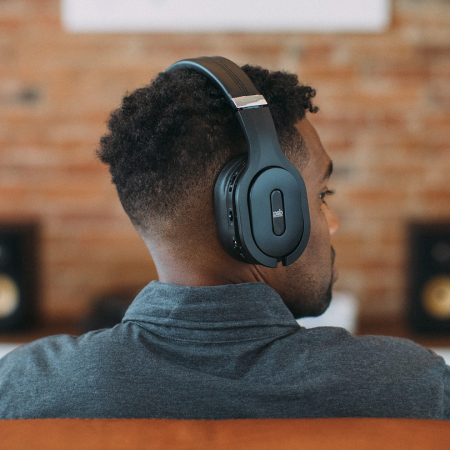 A man listening on a PSB M4U 8 MKII black headphone.